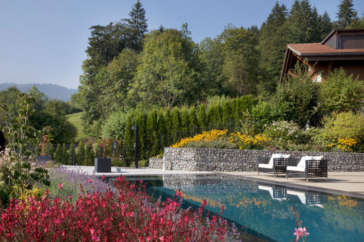 piscine dans un jardin fleuri paysager am&eacute;nag&eacute;