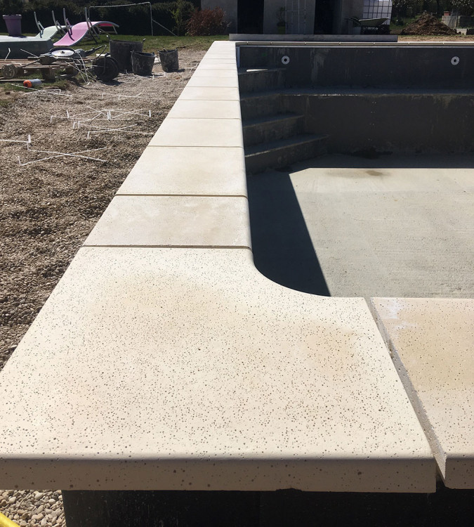 Etape de pose des margelles lors d'une construction de piscine Unib&eacute;o