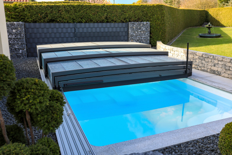 ALUKOV telescopic pool enclosure partially opened, showing retractable segments that provide flexible access to the swimming pool