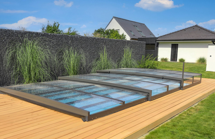 Ultra-low ALUKOV pool enclosure closed over a residential swimming pool with minimal visual impact on the surrounding garden