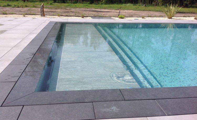 Une piscine &agrave; d&eacute;bordement ISI-Miroir et le caillebotis pour couverture immerg&eacute;e TOP-COVER